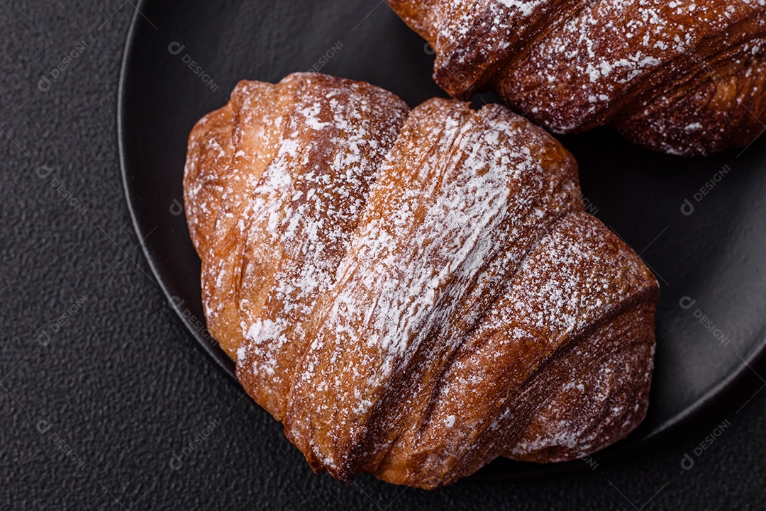 Delicioso croissant crocante doce fresco com chocolate em fundo escuro de concreto