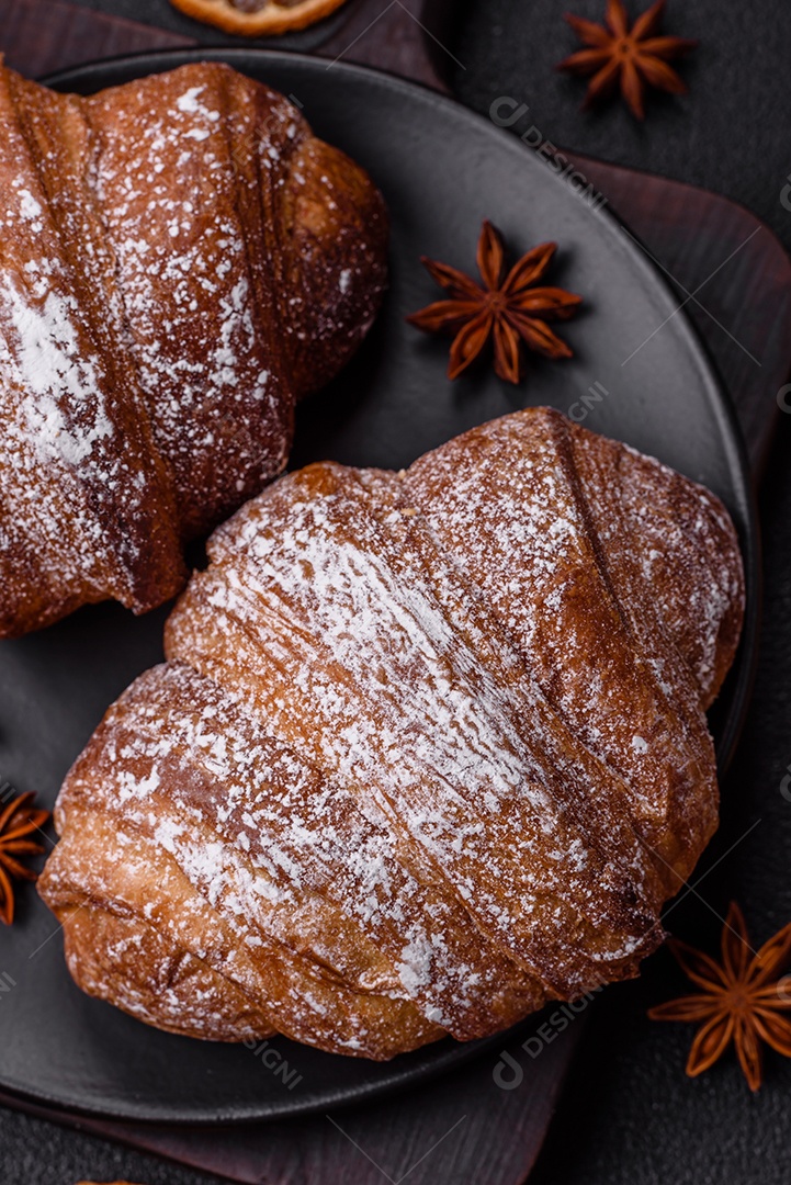 Delicioso croissant crocante doce fresco com chocolate em fundo escuro de concreto