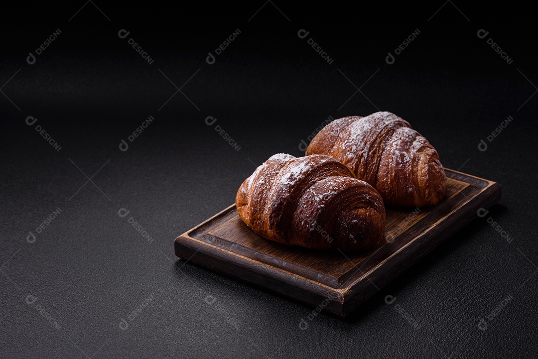 Delicioso croissant crocante doce fresco com chocolate em fundo escuro de concreto