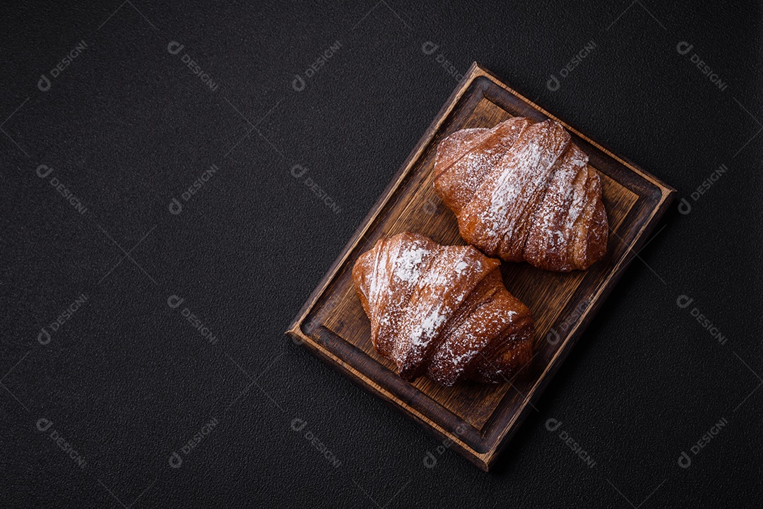 Delicioso croissant crocante doce fresco com chocolate em fundo escuro de concreto