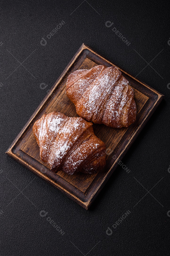 Delicioso croissant crocante doce fresco com chocolate em fundo escuro de concreto