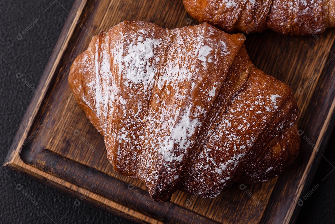 Delicioso croissant crocante doce fresco com chocolate em fundo escuro de concreto
