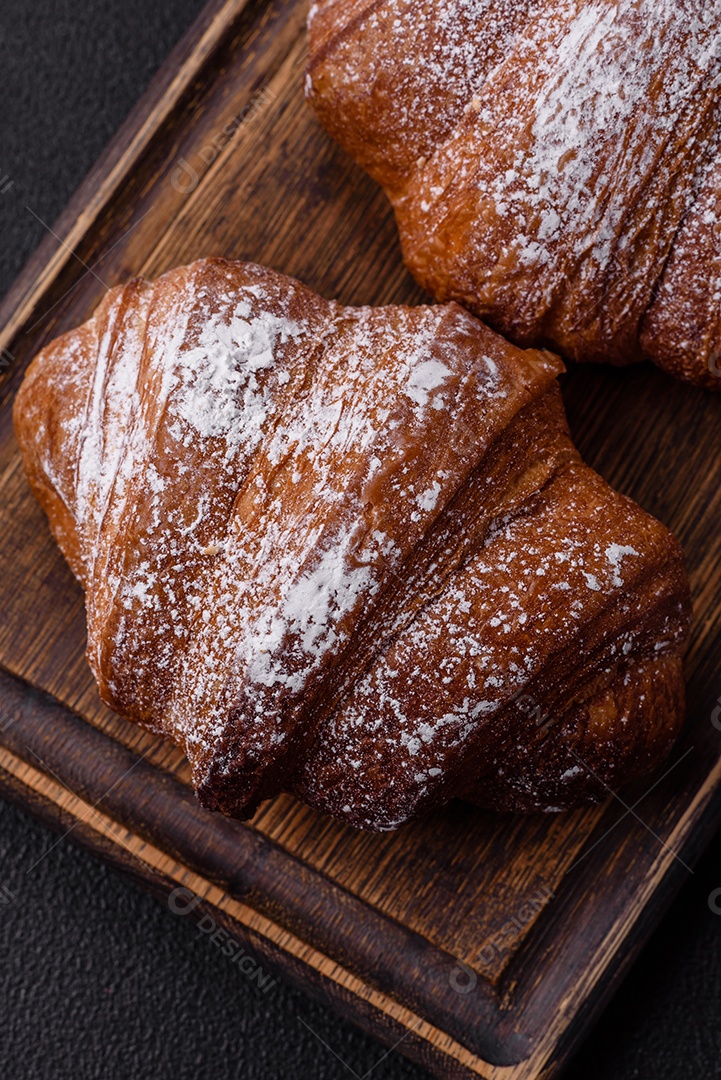 Delicioso croissant crocante doce fresco com chocolate em fundo escuro de concreto