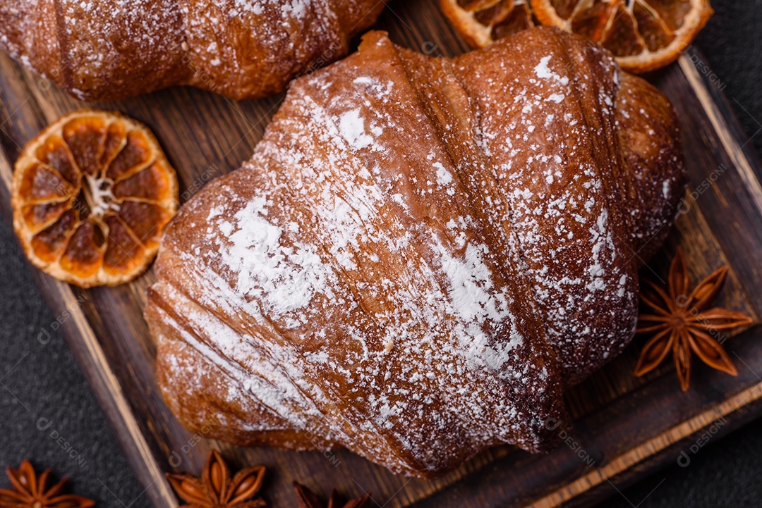 Delicioso croissant crocante doce fresco com chocolate em fundo escuro de concreto