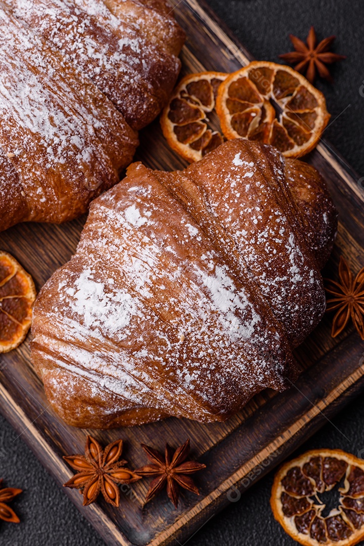 Delicioso croissant crocante doce fresco com chocolate em fundo escuro de concreto