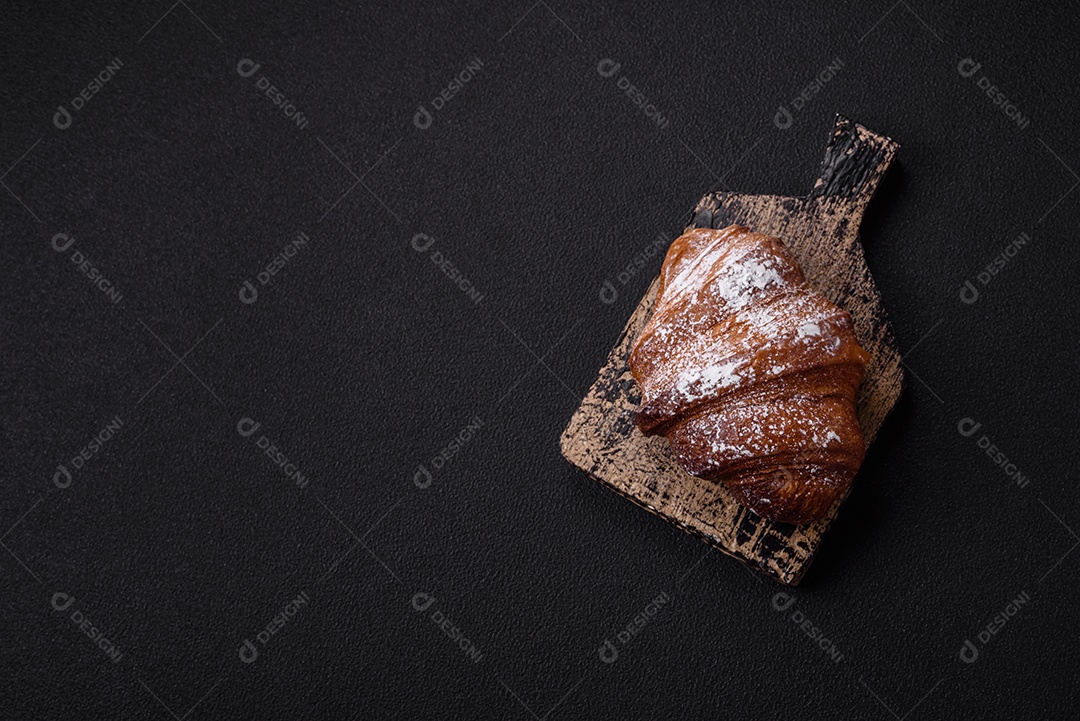 Delicioso croissant crocante doce fresco com chocolate em fundo escuro de concreto