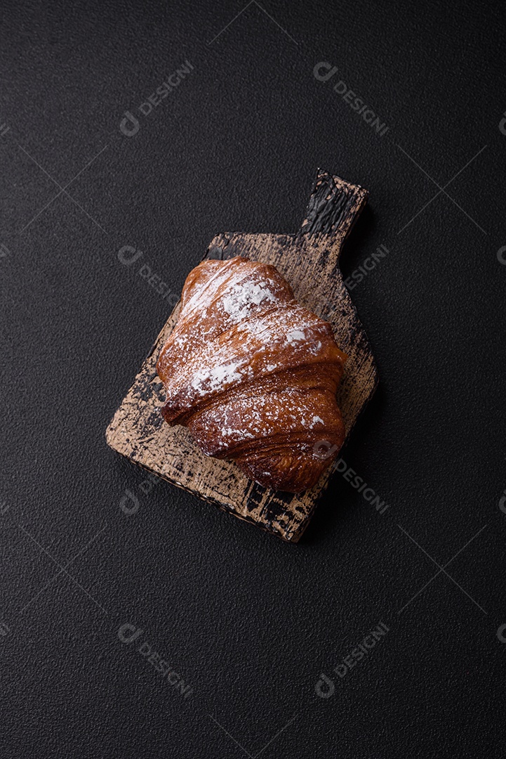 Delicioso croissant crocante doce fresco com chocolate em fundo escuro de concreto