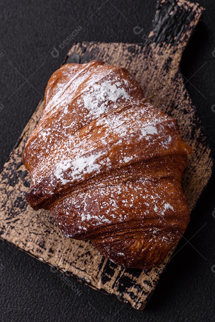 Delicioso croissant crocante doce fresco com chocolate em fundo escuro de concreto