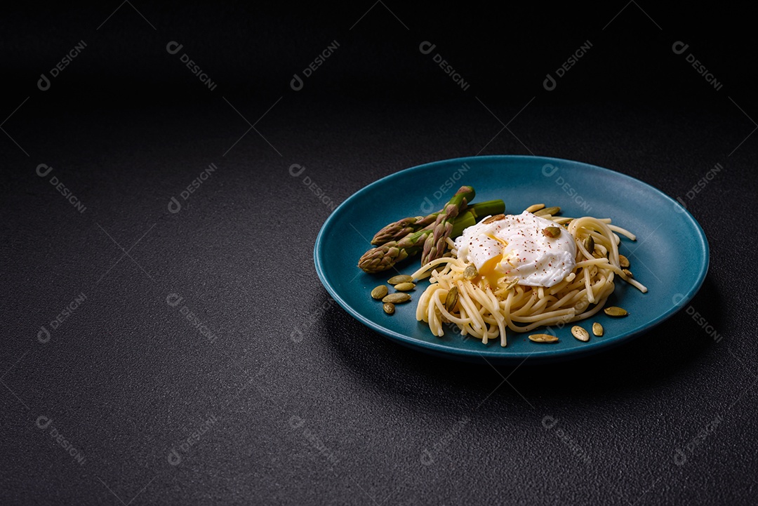Delicioso café da manhã composto por ovos escalfados com torradas com cream cheese, aspargos, sal e especiarias em um fundo escuro de concreto
