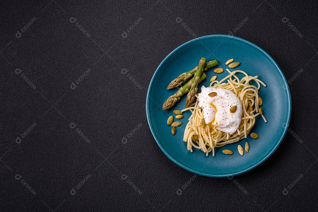 Delicioso café da manhã composto por ovos escalfados com torradas com cream cheese, aspargos, sal e especiarias em um fundo escuro de concreto