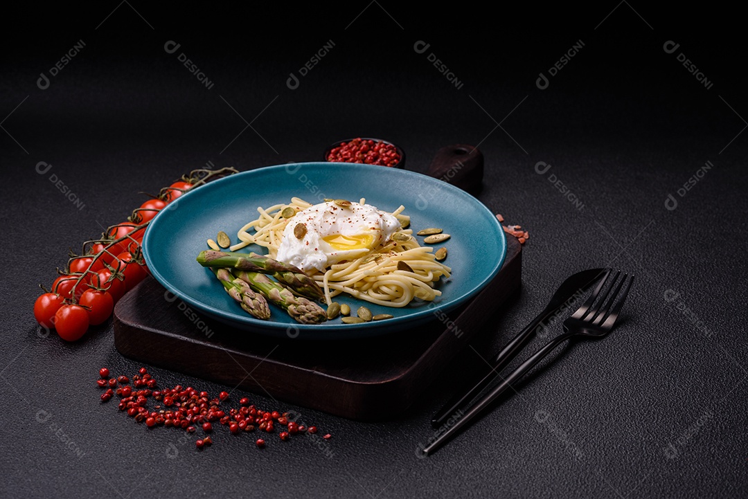 Delicioso café da manhã composto por ovos escalfados com torradas com cream cheese, aspargos, sal e especiarias em um fundo escuro de concreto