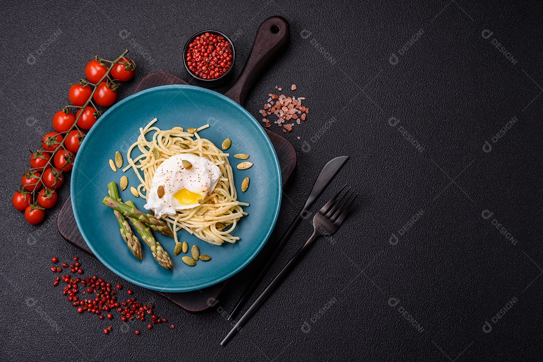 Delicioso café da manhã composto por ovos escalfados com torradas com cream cheese, aspargos, sal e especiarias em um fundo escuro de concreto