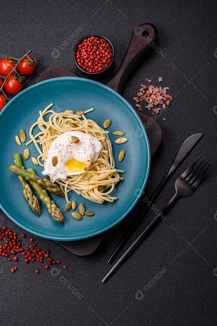 Delicioso café da manhã composto por ovos escalfados com torradas com cream cheese, aspargos, sal e especiarias em um fundo escuro de concreto