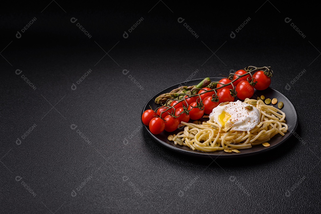 Delicioso café da manhã composto por ovos escalfados com torradas com cream cheese, aspargos, sal e especiarias em um fundo escuro de concreto