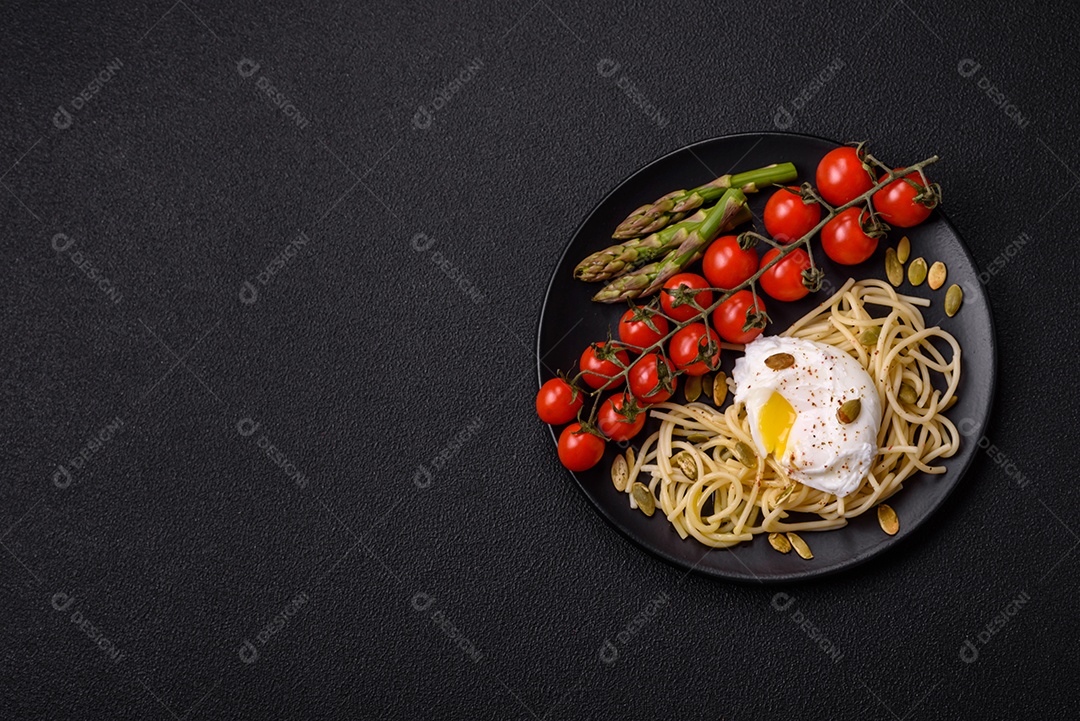 Delicioso café da manhã composto por ovos escalfados com torradas com cream cheese, aspargos, sal e especiarias em um fundo escuro de concreto