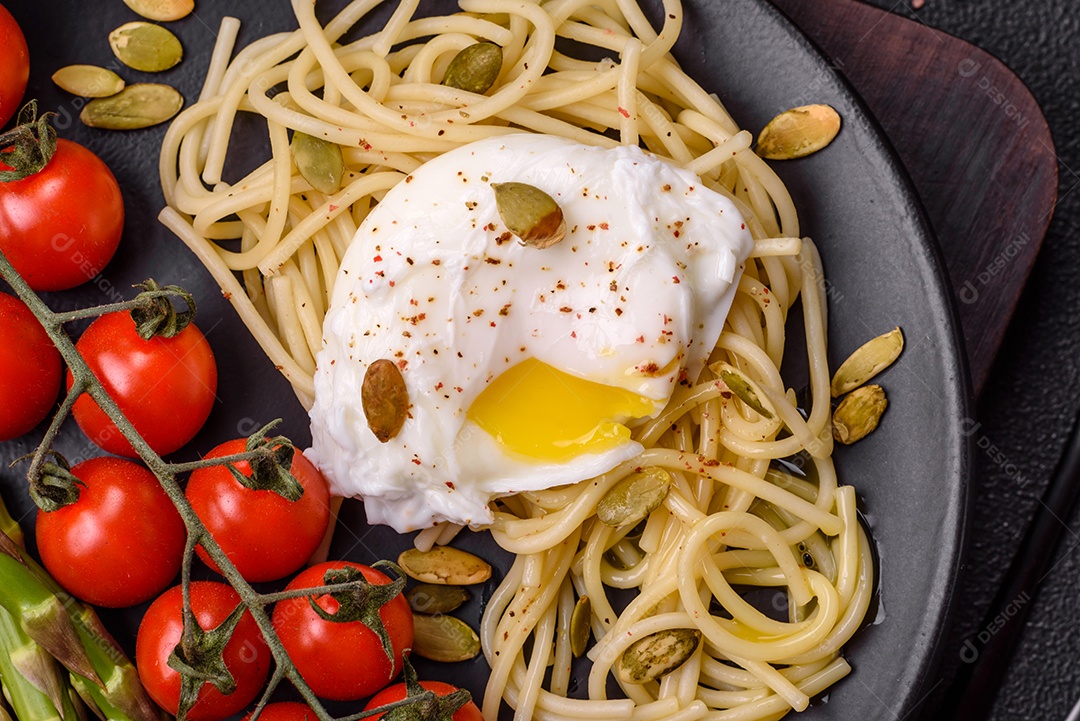 Delicioso café da manhã composto por ovos escalfados com torradas com cream cheese, aspargos, sal e especiarias em um fundo escuro de concreto