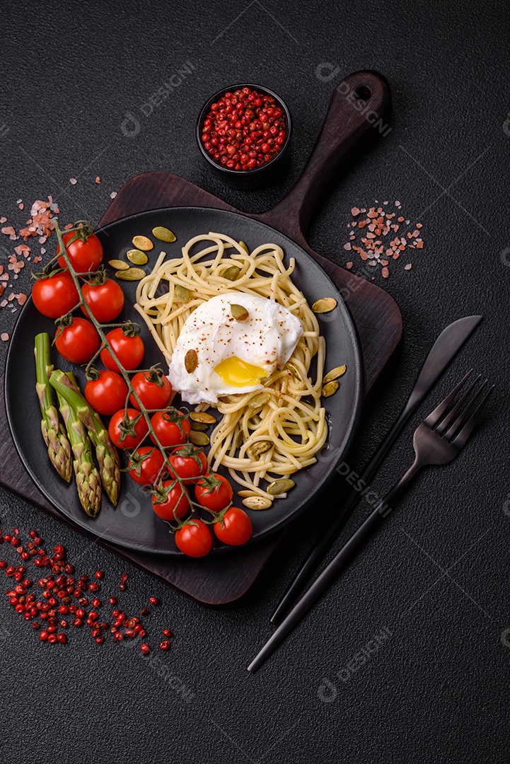 Delicioso café da manhã composto por ovos escalfados com torradas com cream cheese, aspargos, sal e especiarias em um fundo escuro de concreto