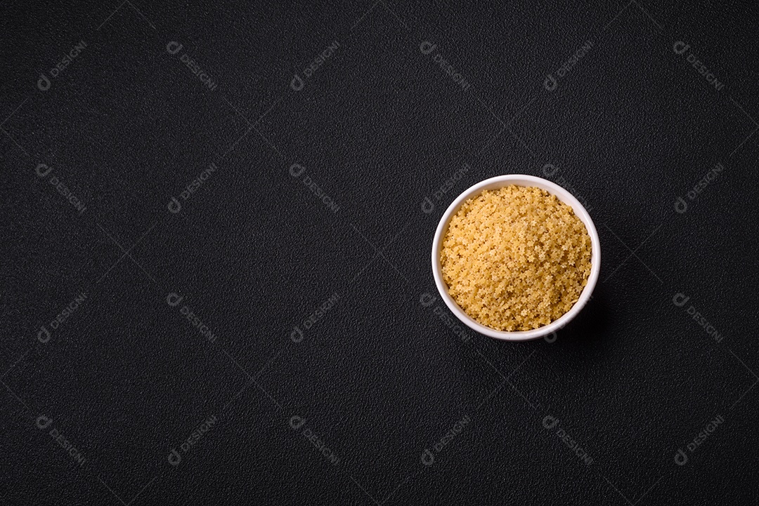 Massa anellini crua de trigo duro com sal e especiarias sobre um fundo escuro de concreto