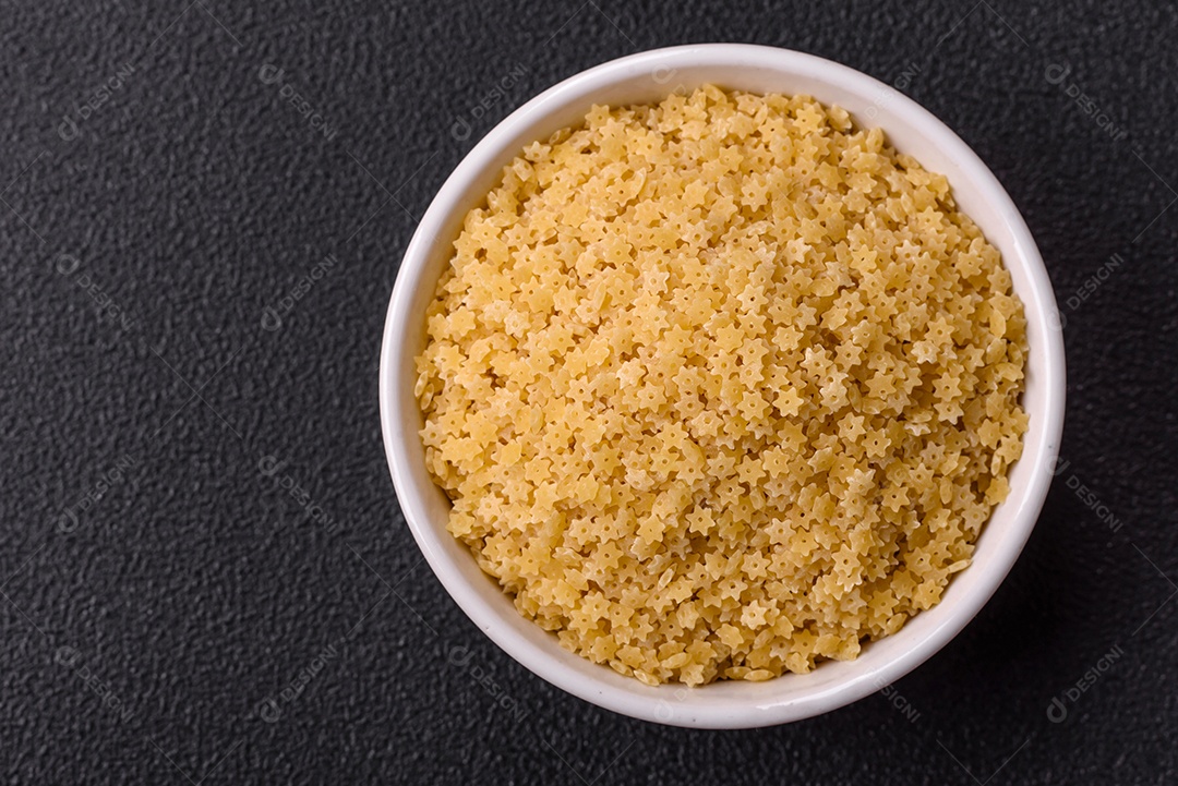 Massa anellini crua de trigo duro com sal e especiarias sobre um fundo escuro de concret