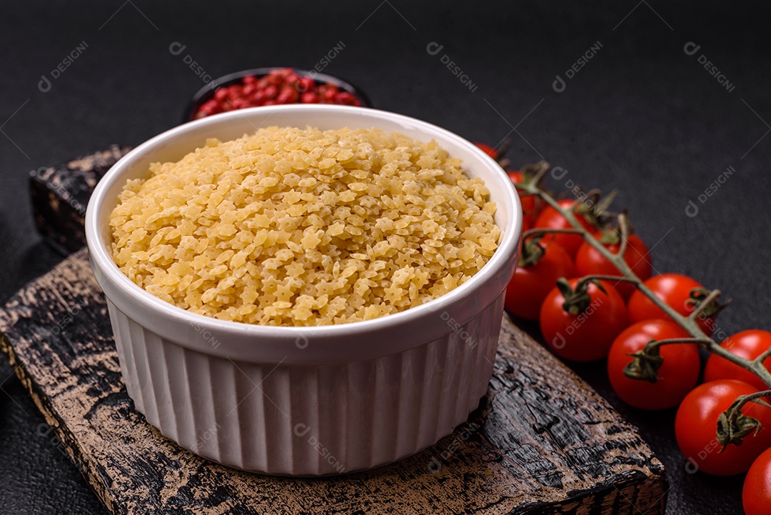 Massa anellini crua de trigo duro com sal e especiarias sobre um fundo escuro de concreto