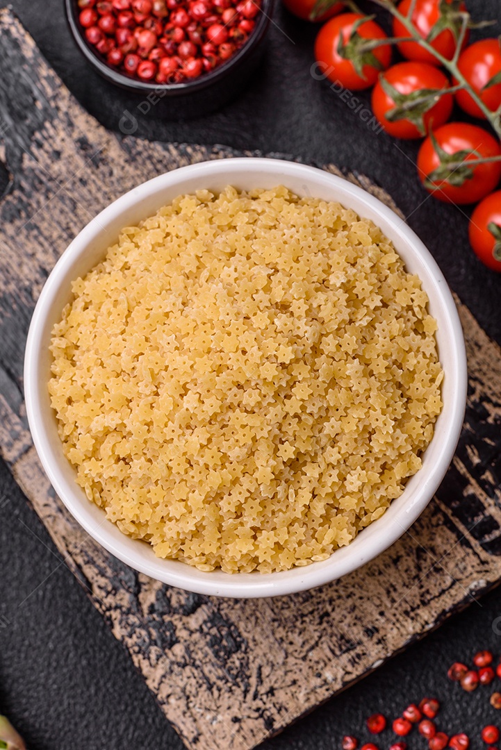 Massa anellini crua de trigo duro com sal e especiarias sobre um fundo escuro de concreto