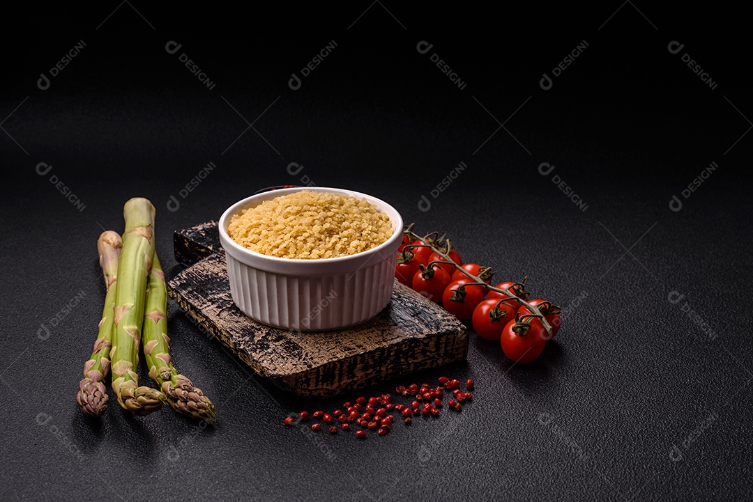 Massa anellini crua de trigo duro com sal e especiarias sobre um fundo escuro de concreto