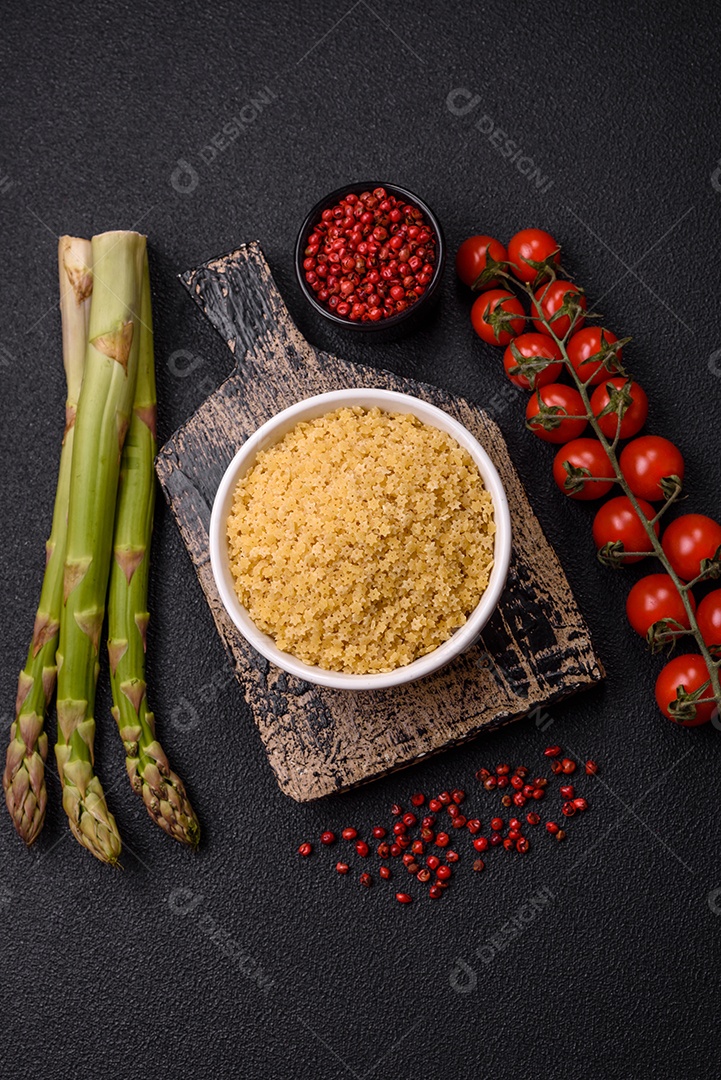 Massa anellini crua de trigo duro com sal e especiarias sobre um fundo escuro de concreto