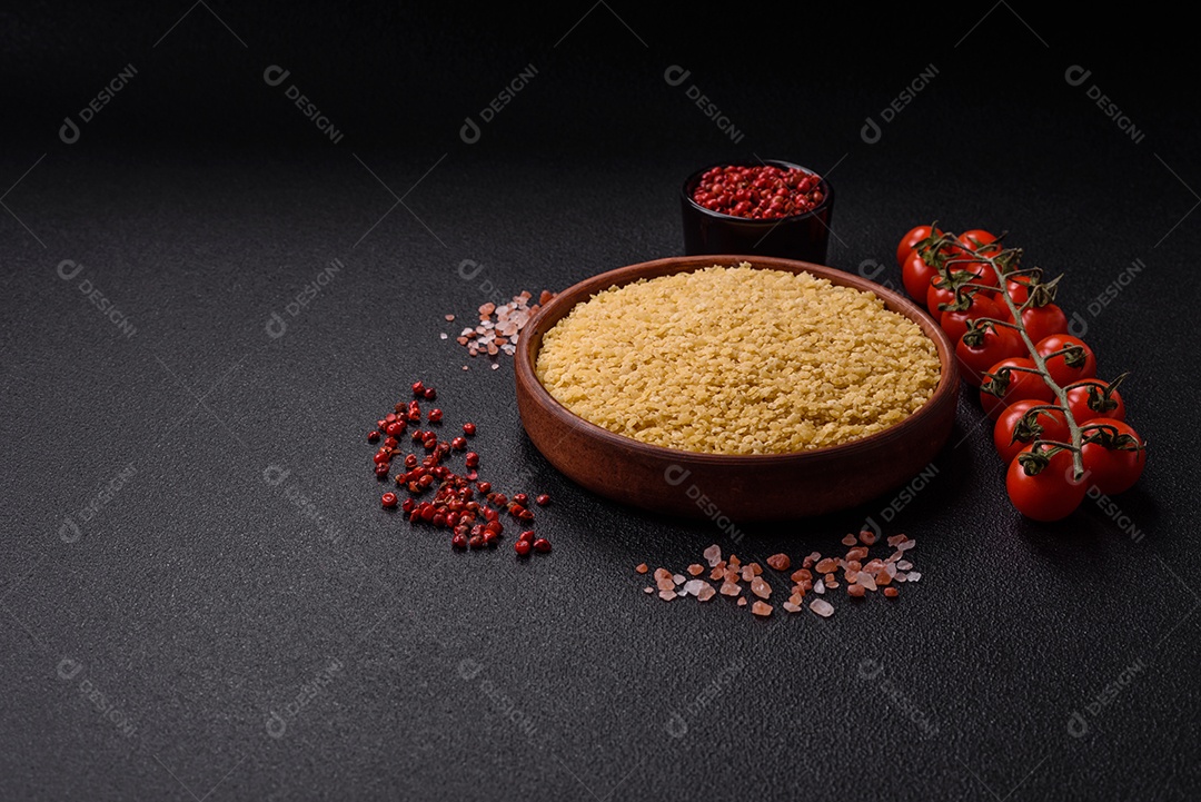 Massa anellini crua de trigo duro com sal e especiarias sobre um fundo escuro de concreto