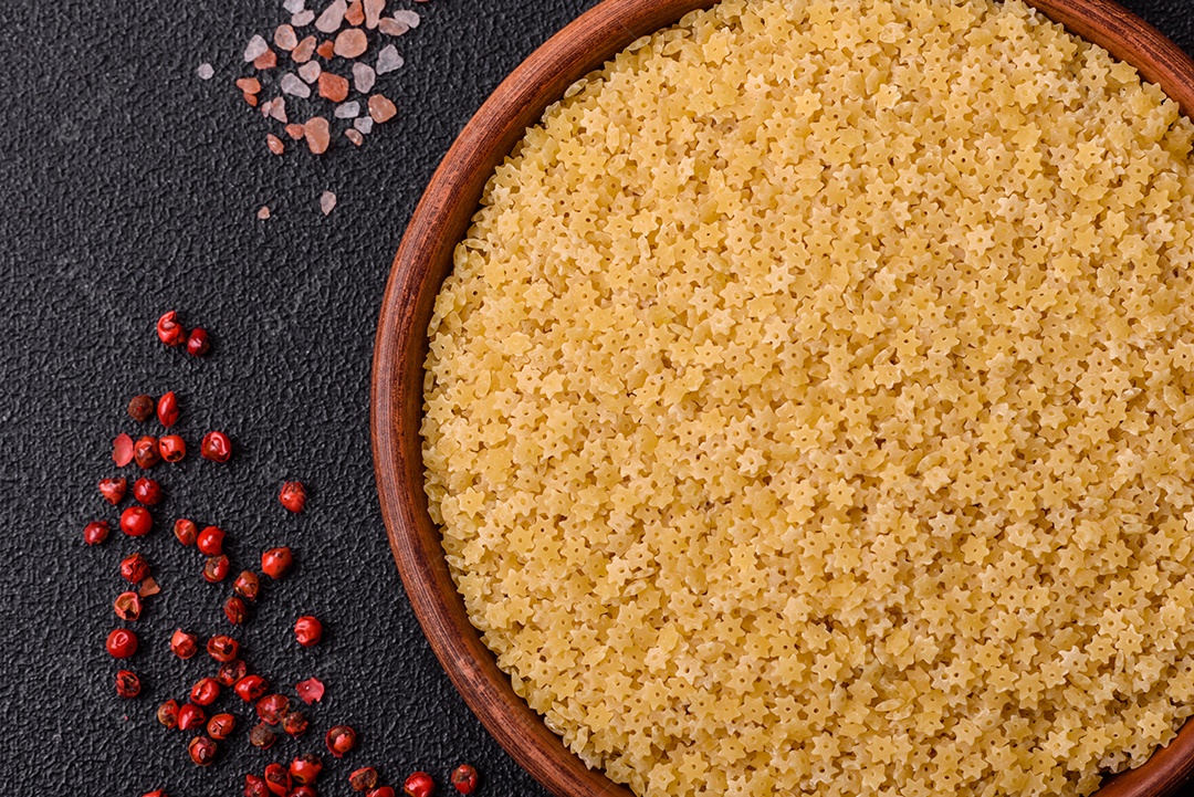 Massa anellini crua de trigo duro com sal e especiarias sobre um fundo escuro de concreto