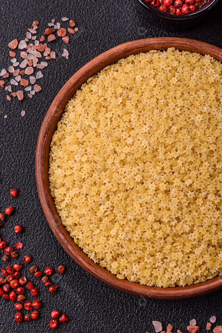 Massa anellini crua de trigo duro com sal e especiarias sobre um fundo escuro de concreto