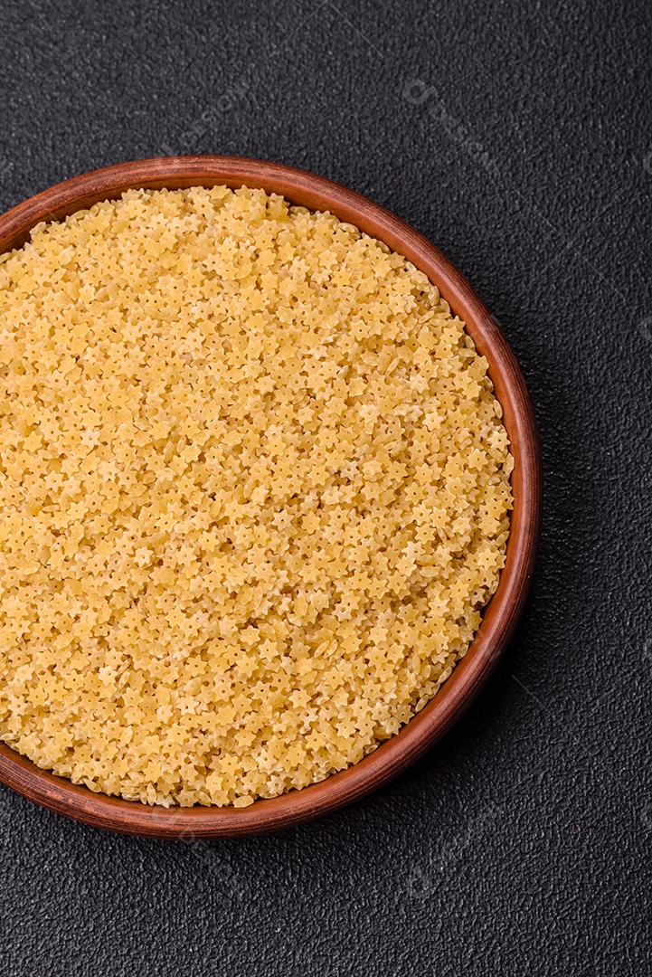 Massa anellini crua de trigo duro com sal e especiarias sobre um fundo escuro de concreto