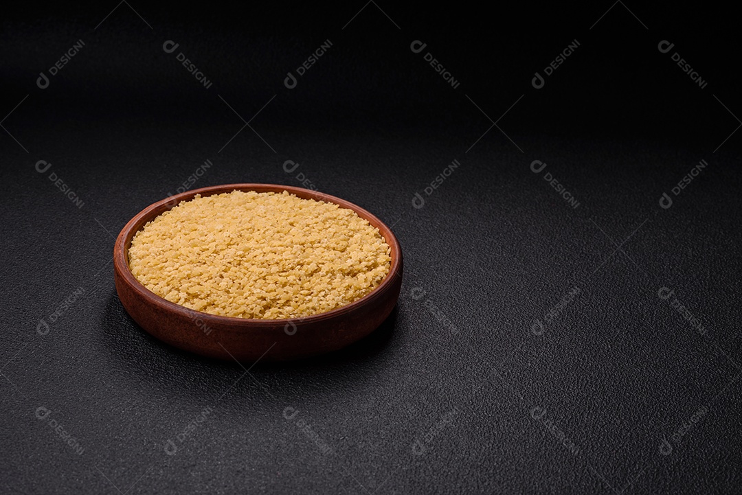 Massa anellini crua de trigo duro com sal e especiarias sobre um fundo escuro de concreto