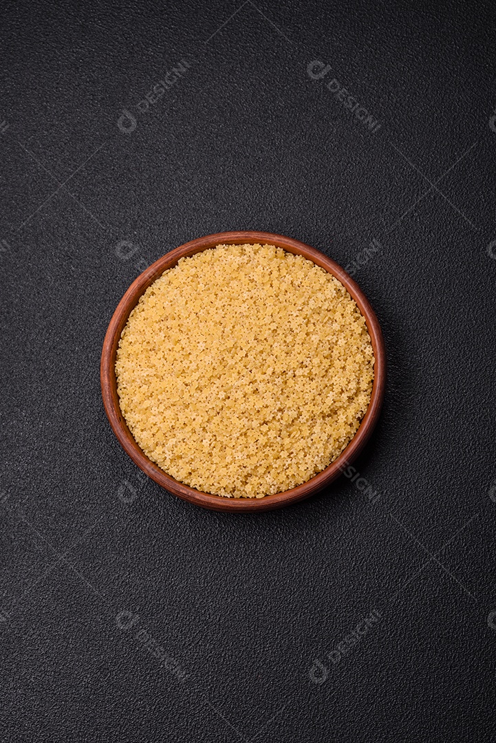 Massa anellini crua de trigo duro com sal e especiarias sobre um fundo escuro de concreto