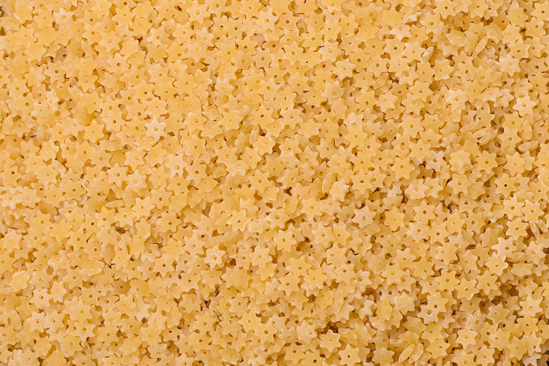 Massa anellini crua de trigo duro com sal e especiarias sobre um fundo escuro de concreto