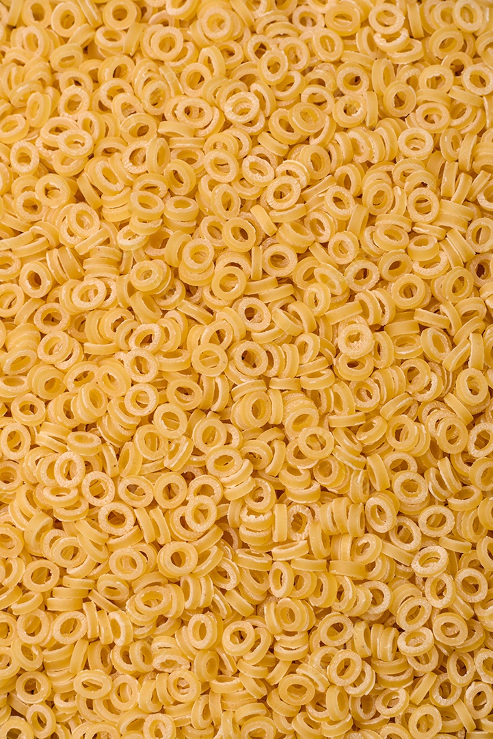 Massa anellini crua de trigo duro com sal e especiarias sobre um fundo escuro de concreto