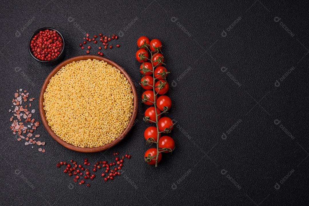 Massa anellini crua de trigo duro com sal e especiarias sobre um fundo escuro de concreto