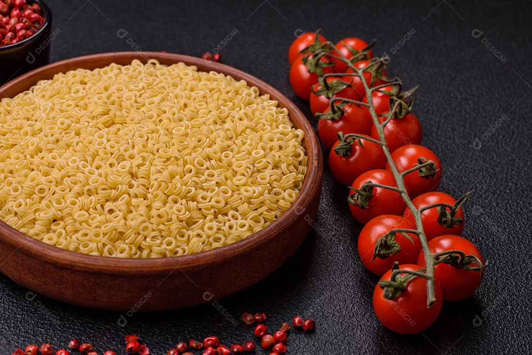 Massa anellini crua de trigo duro com sal e especiarias sobre um fundo escuro de concreto