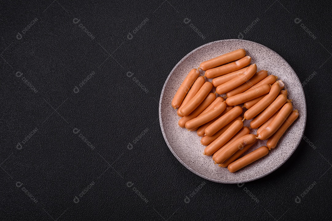 Deliciosas salsichas vegetarianas ou veganas com sal, especiarias e ervas sobre um fundo escuro de concreto