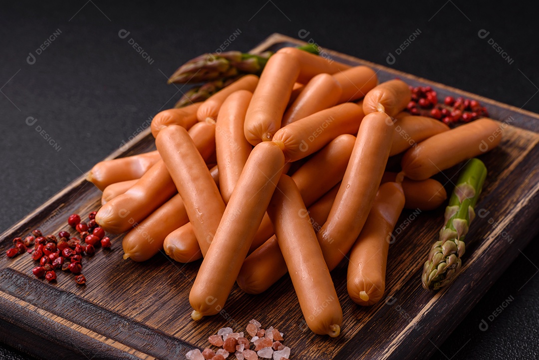 Deliciosas salsichas vegetarianas ou veganas com sal, especiarias e ervas sobre um fundo escuro de concreto