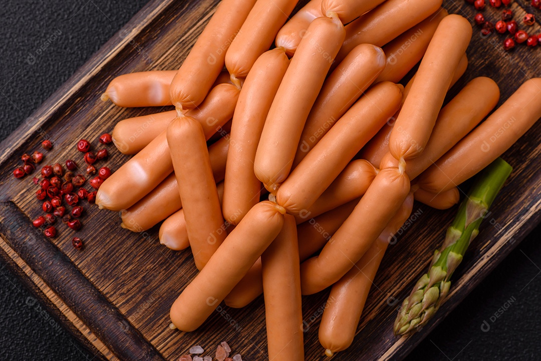 Deliciosas salsichas vegetarianas ou veganas com sal, especiarias e ervas sobre um fundo escuro de concreto