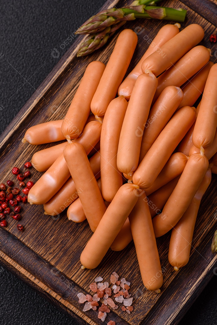 Deliciosas salsichas vegetarianas ou veganas com sal, especiarias e ervas sobre um fundo escuro de concreto