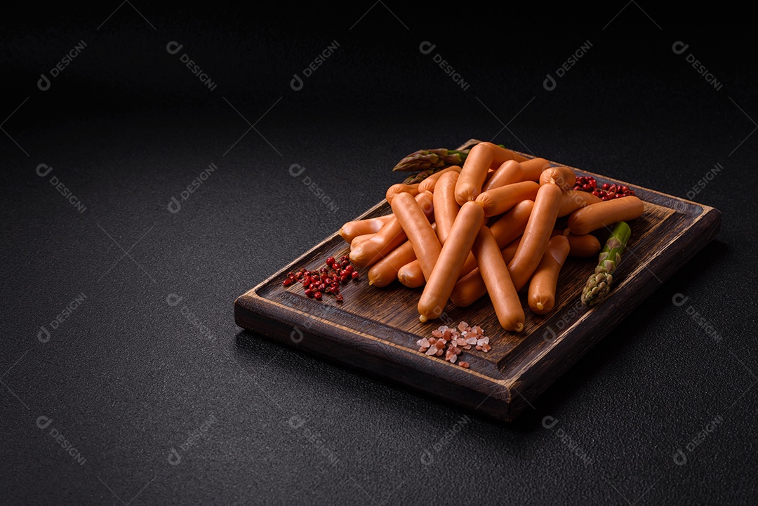 Deliciosas salsichas vegetarianas ou veganas com sal, especiarias e ervas sobre um fundo escuro de concreto