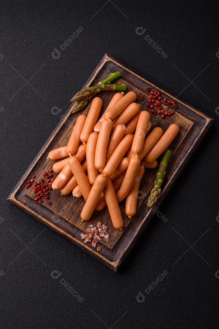 Deliciosas salsichas vegetarianas ou veganas com sal, especiarias e ervas sobre um fundo escuro de concreto