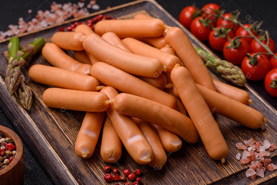 Deliciosas salsichas vegetarianas ou veganas com sal, especiarias e ervas sobre um fundo escuro de concreto