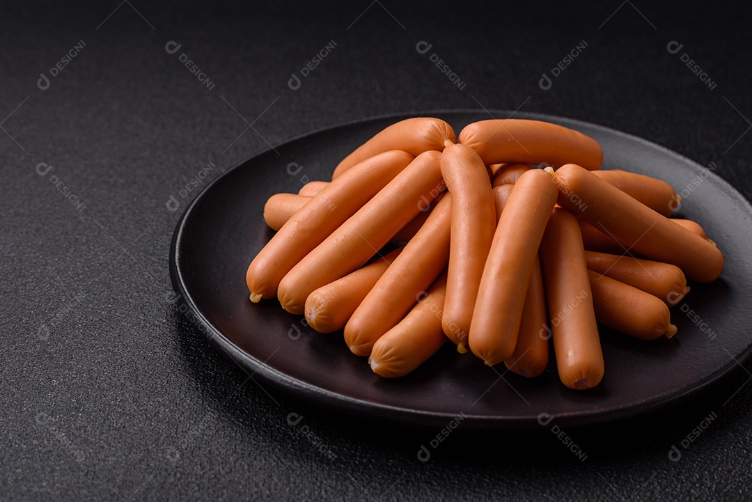 Deliciosas salsichas vegetarianas ou veganas com sal, especiarias e ervas sobre um fundo escuro de concreto