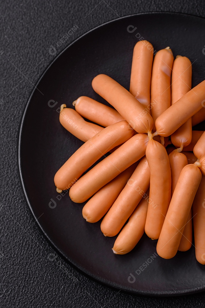 Deliciosas salsichas vegetarianas ou veganas com sal, especiarias e ervas sobre um fundo escuro de concreto