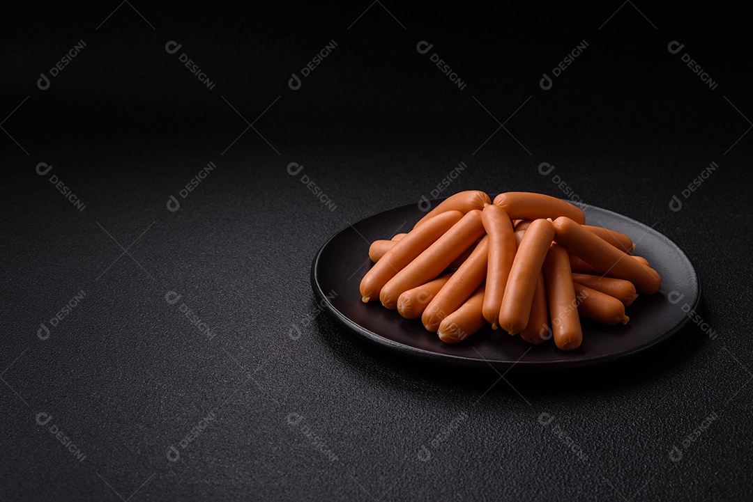 Deliciosas salsichas vegetarianas ou veganas com sal, especiarias e ervas sobre um fundo escuro de concreto