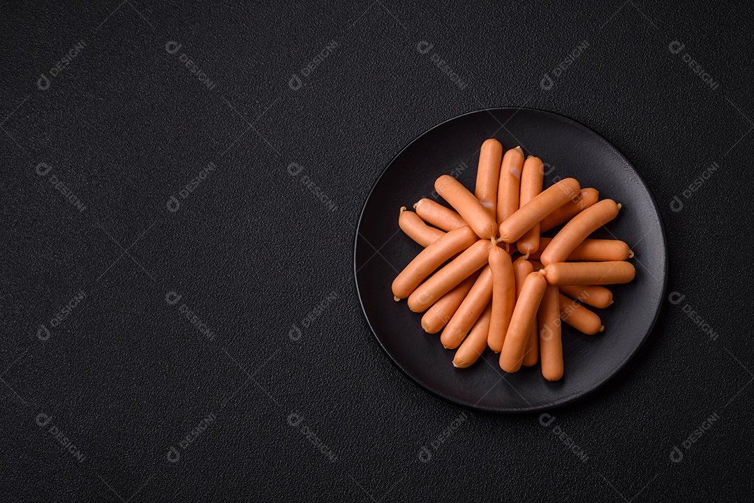 Deliciosas salsichas vegetarianas ou veganas com sal, especiarias e ervas sobre um fundo escuro de concreto