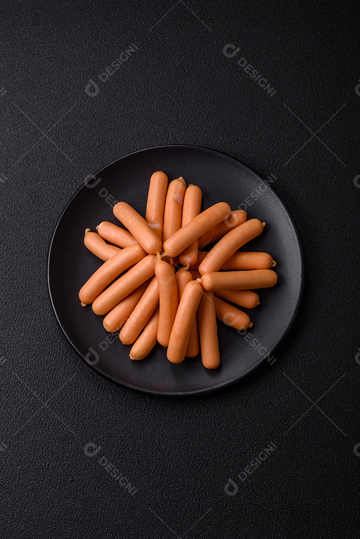 Deliciosas salsichas vegetarianas ou veganas com sal, especiarias e ervas sobre um fundo escuro de concreto