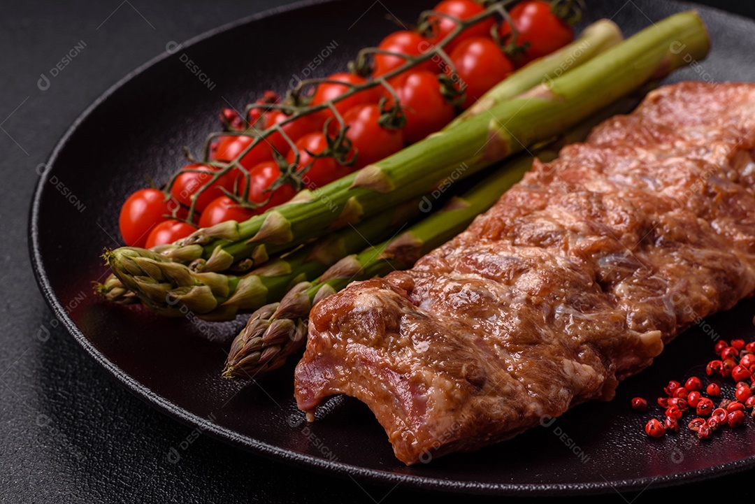 Costelas de porco cruas marinadas com sal, especiarias e ervas sobre um fundo escuro de concreto